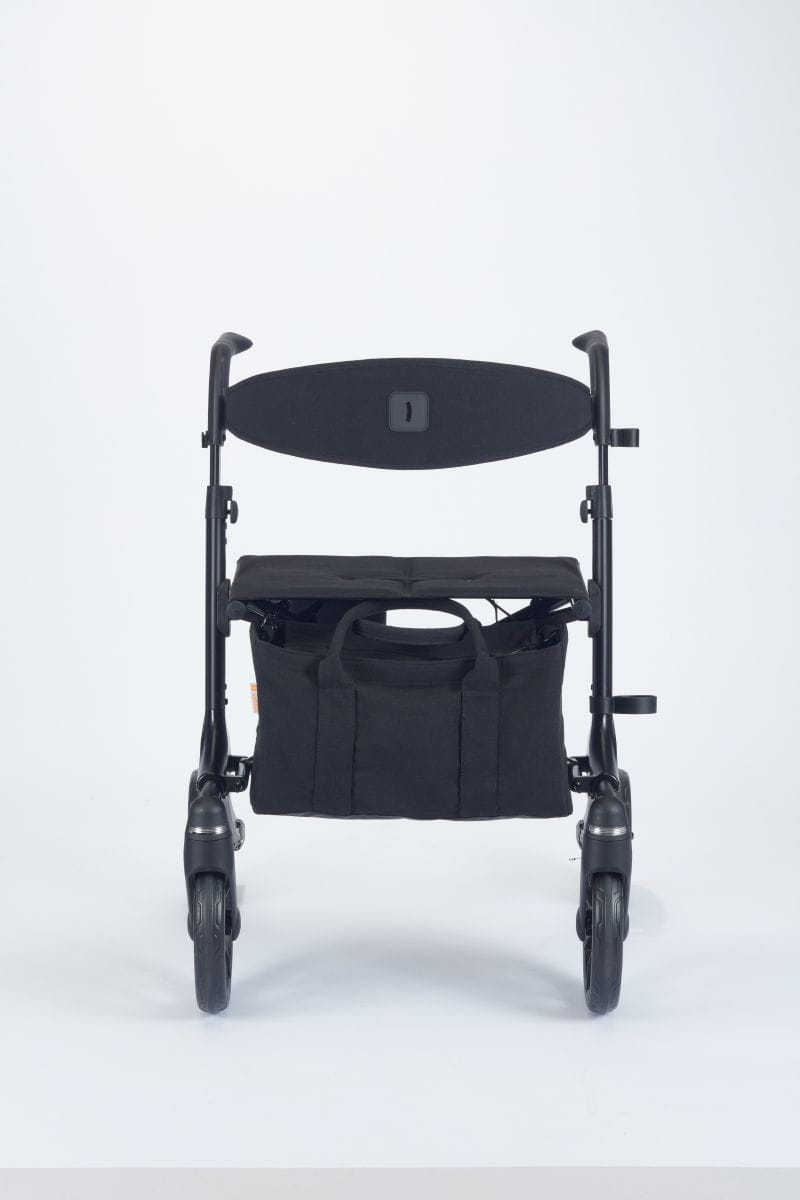 Frontansicht eines graphit-schwarzen, Reise-Rollator, Modell Resi von Smina, mit Rückengurt, Tasche und Softbereifung.