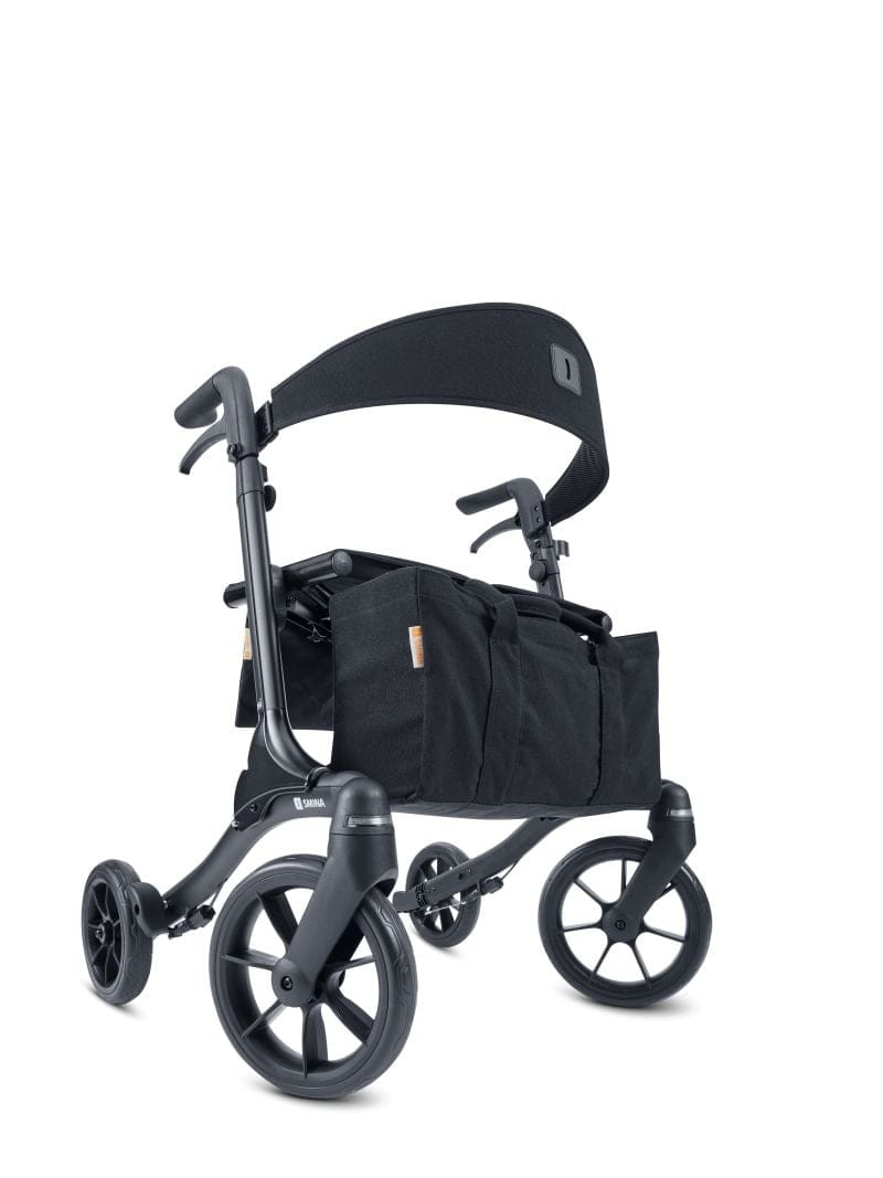 Seitenansicht eines graphit-schwarzen, Reise-Rollator, Modell Resi von Smina, mit Rückengurt, Tasche und Softbereifun