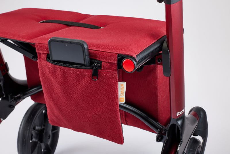 Frontperspektive des faltbaren Polstersitz, mit integrierter Tasche, von dem SMINA Reise-Rollator Resi