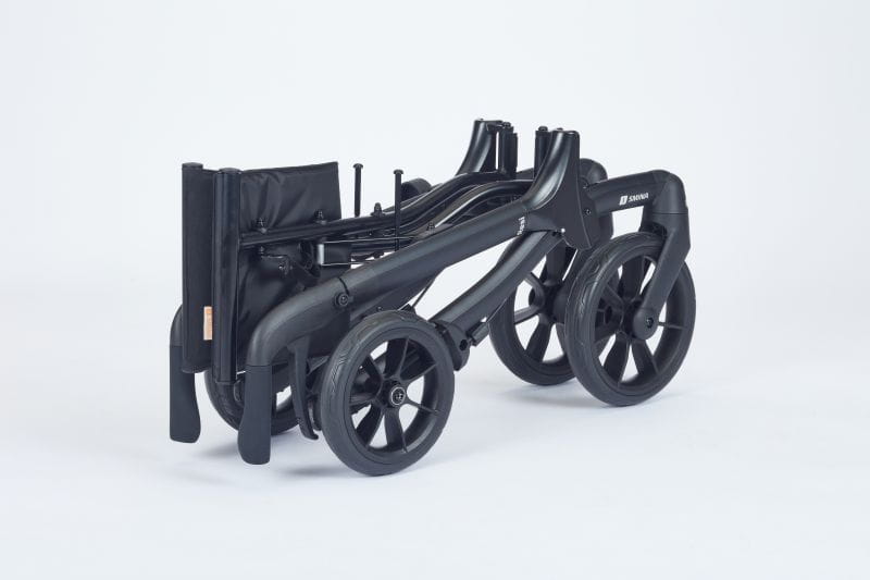 Reise-Rollator zusammengeklappt (zweifach bzw. doppelt), Seitensicht, Modell Resi von Smina, eines carbon-schwarzen